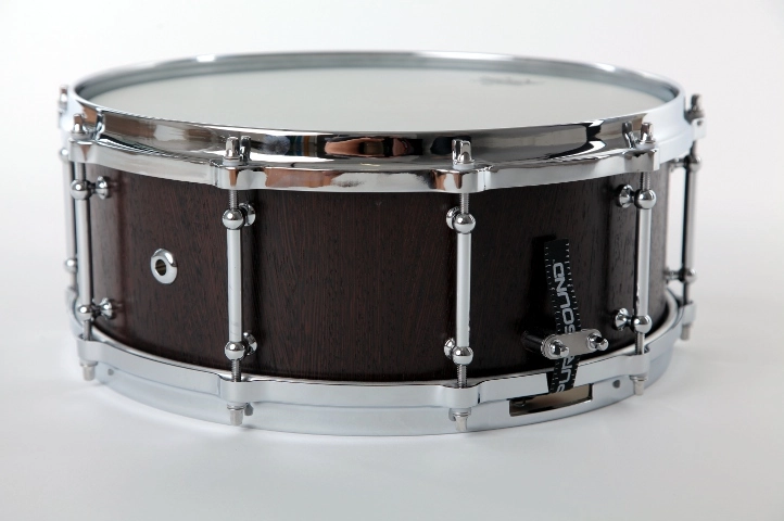 Snaredrum-wenge. Snare-Drum mit dunklem Holzfinish, verchromter Hardware und 'Sound'-Badge auf dem Kessel.